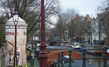 Spacer po Jordaan dzielnicy artystów w Amsterdamie od robotniczych domów do galerii Kanał w Amsterdamie z łodziami i historycznymi kamienicami w Jordaan
