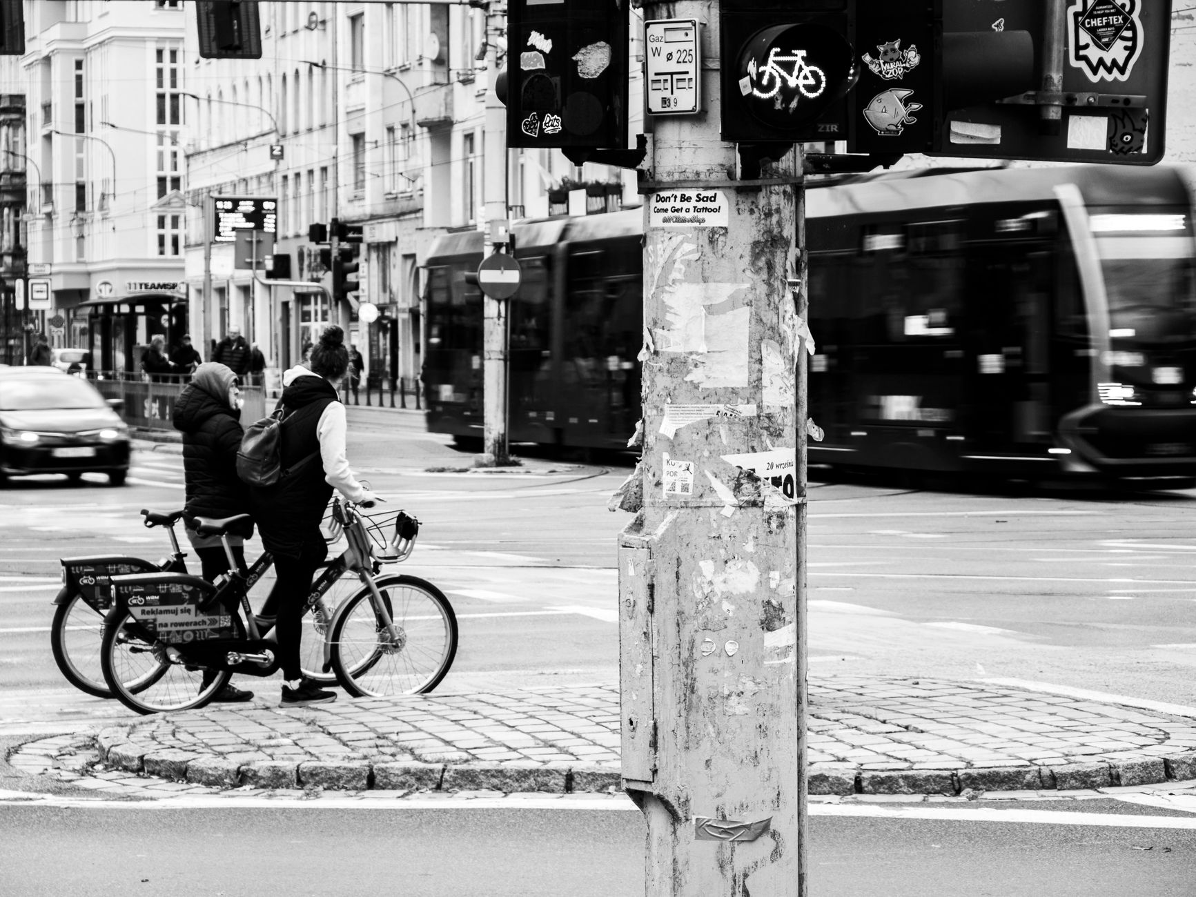 Dwóch rowerzystów czeka na ruchliwym miejskim skrzyżowaniu